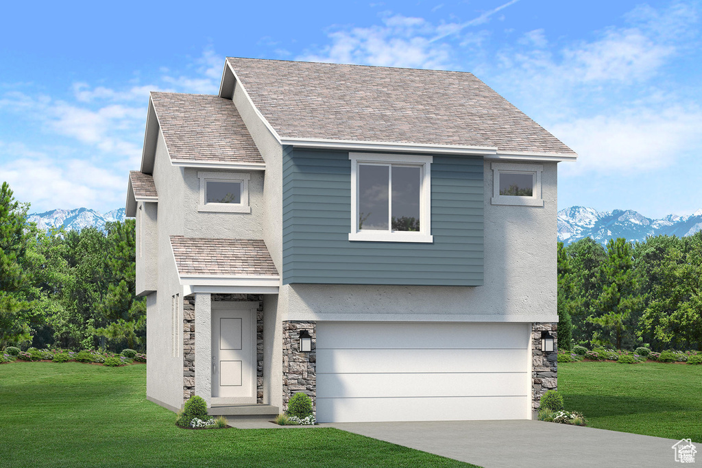 View of front of home with a mountain view, an attached garage, and a front yard
