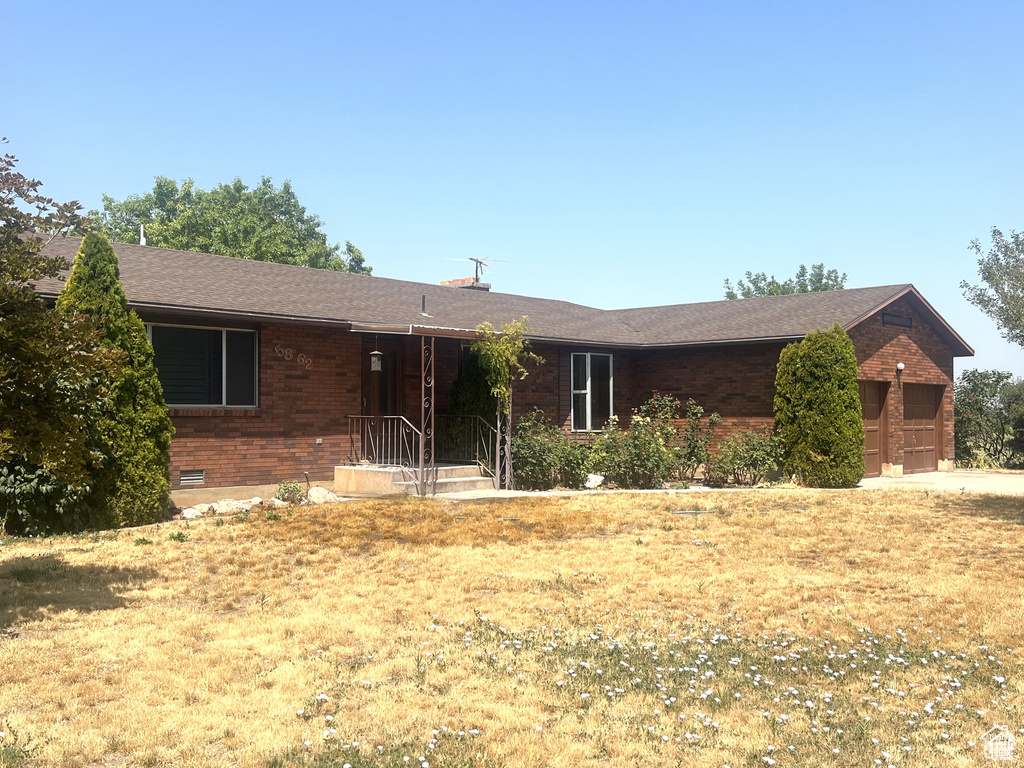 Single story home with crawl space, brick siding, and roof with shingles