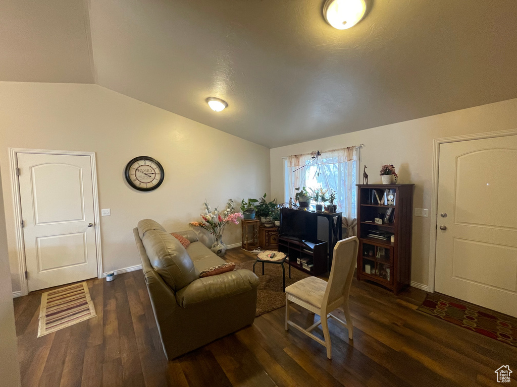 Living area featuring lofted ceiling, wood finished floors, and baseboards