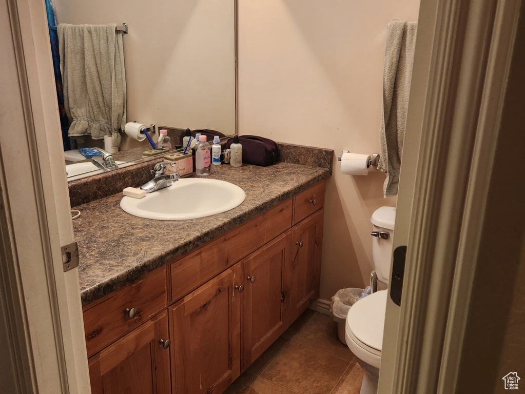 Bathroom featuring tile patterned flooring, toilet, and vanity
