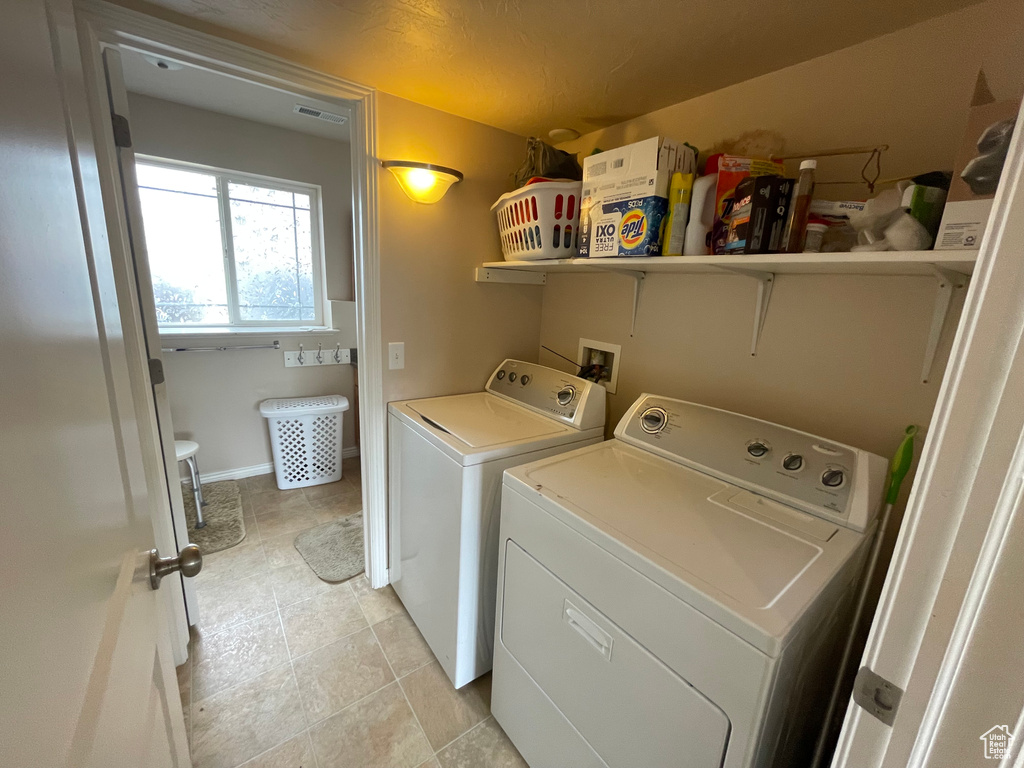 Washroom with washing machine and clothes dryer, laundry area, baseboards, and visible vents