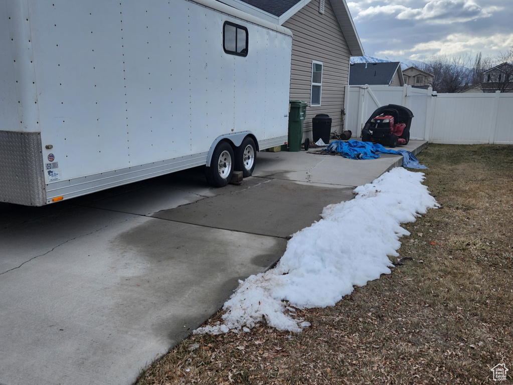 View of side of property with driveway and fence
