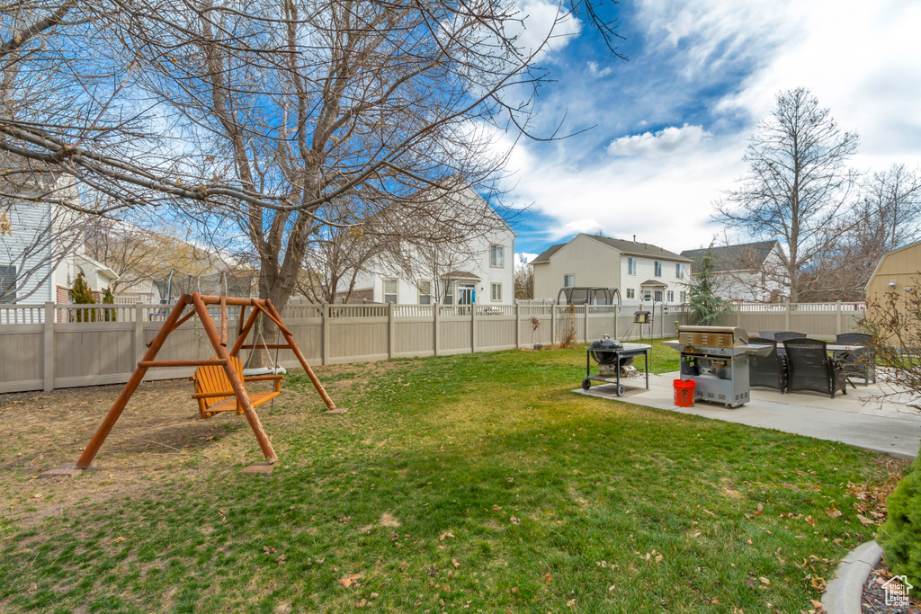 View of yard featuring a residential view, a playground, a fenced backyard, and a patio area