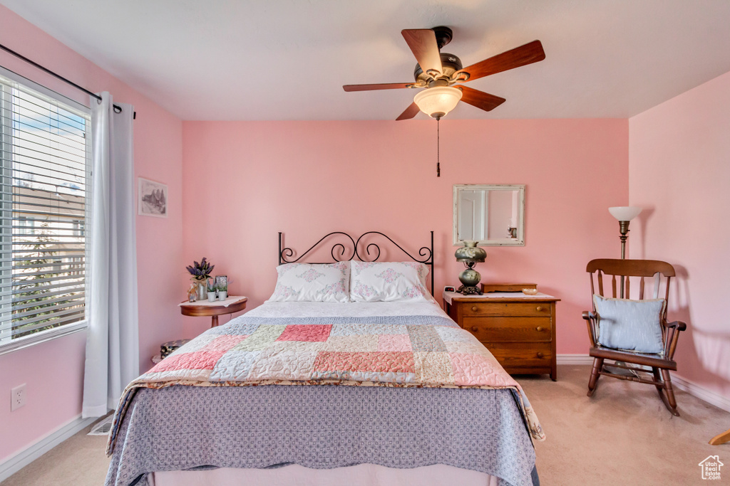Bedroom featuring light colored carpet, baseboards, and multiple windows