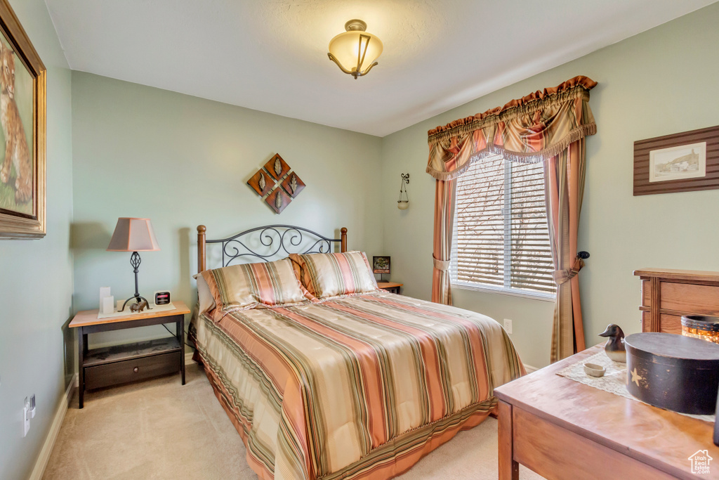 Bedroom with light colored carpet and baseboards