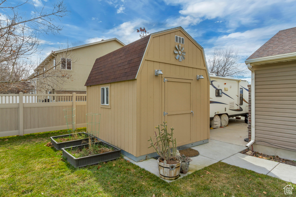 View of shed featuring a vegetable garden and fence