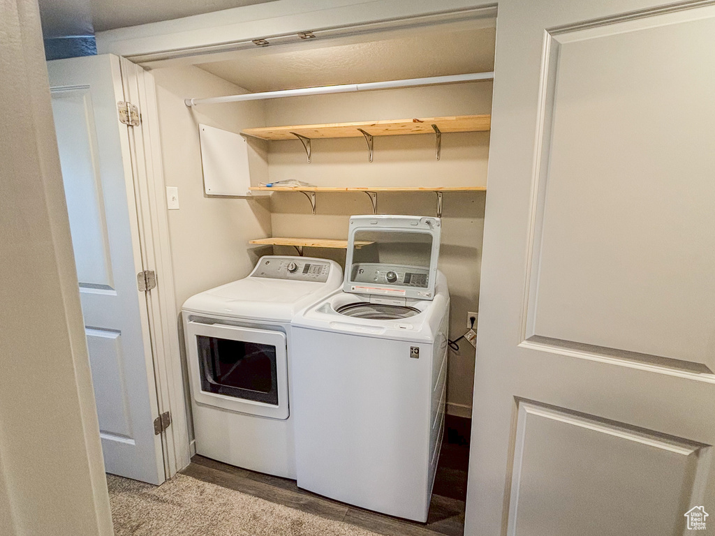 Laundry area featuring light wood-style floors, independent washer and dryer, and laundry area