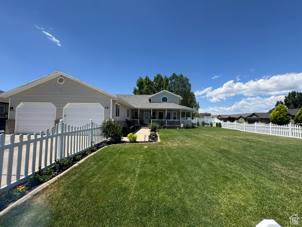 View of front facade with a garage, covered porch, and driveway