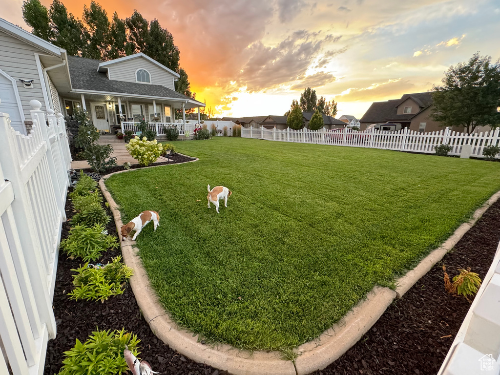 Yard at dusk featuring a fenced backyard