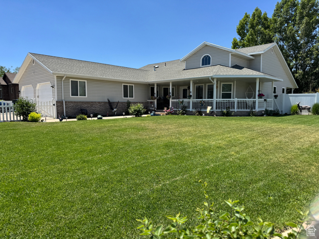 View of front facade with an attached garage, roof with shingles, and a porch
