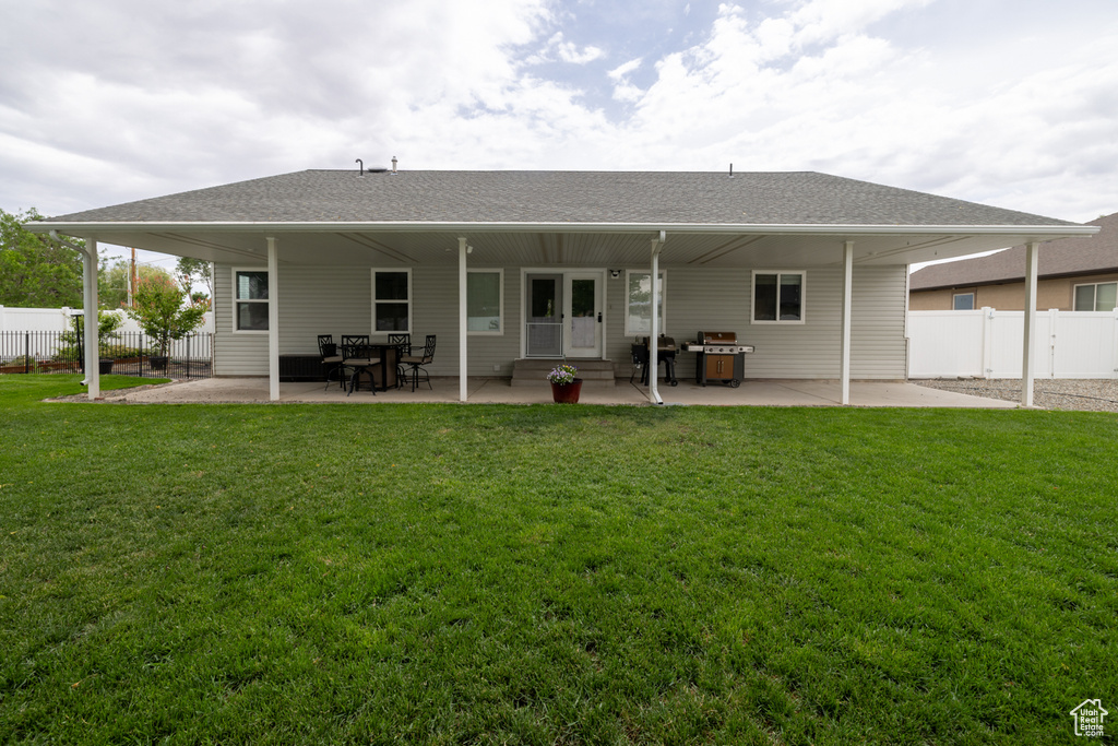 Rear view of property featuring a patio and a shingled roof