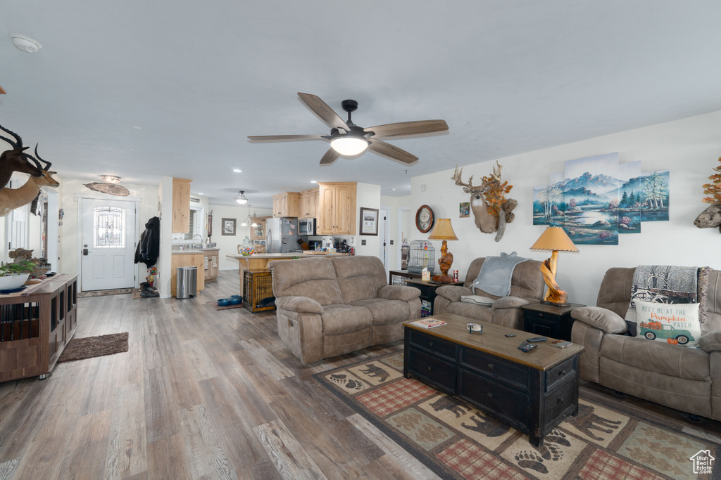 Living area with ceiling fan and wood finished floors