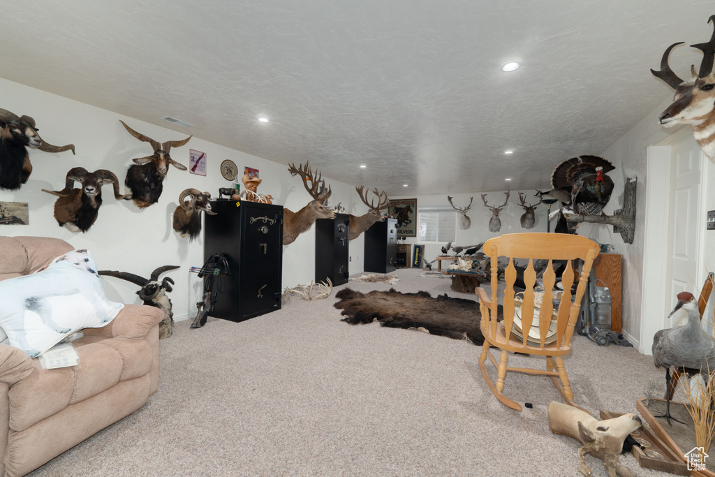 Carpeted living area featuring visible vents, recessed lighting, and a textured ceiling