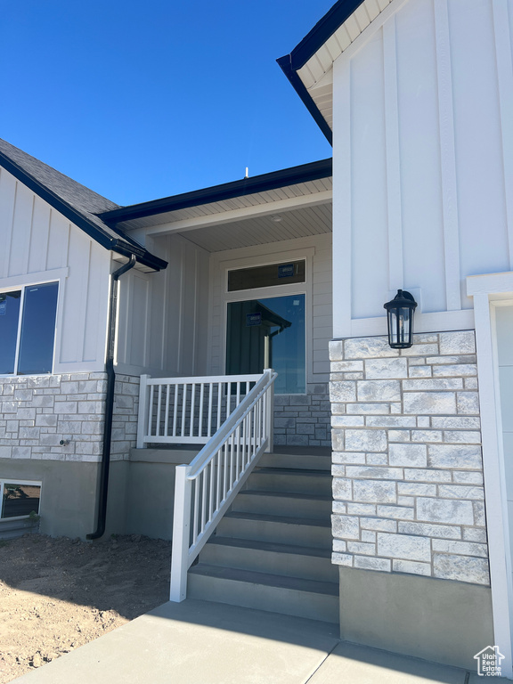 View of exterior entry featuring stone siding and board and batten siding
