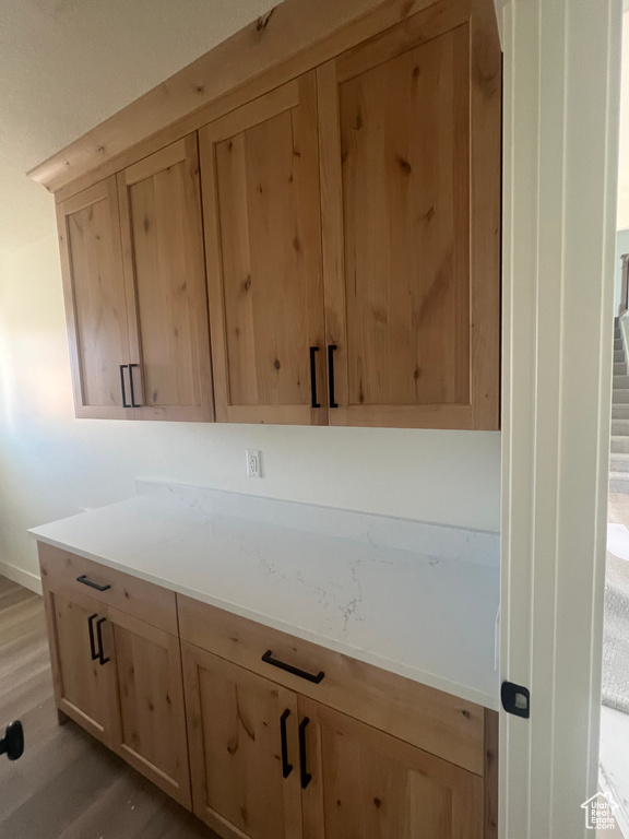 Bar featuring light wood-style floors and baseboards