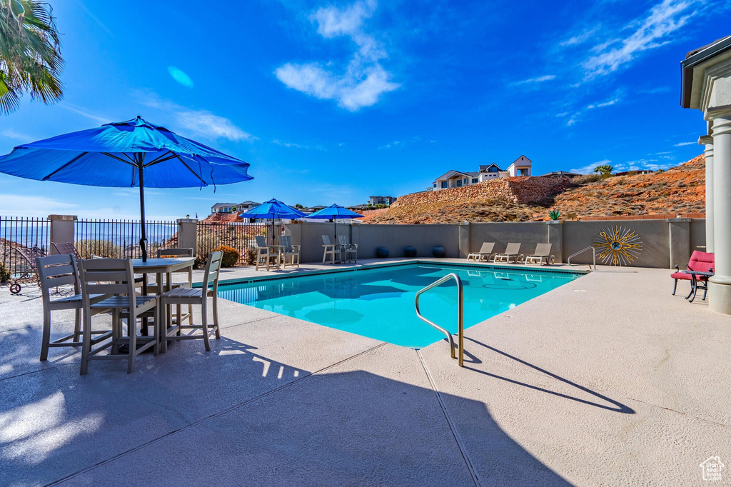 View of swimming pool featuring a patio area, a fenced in pool, and fence
