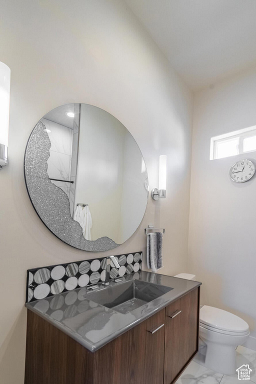 Bathroom featuring marble finish floor, toilet, and vanity