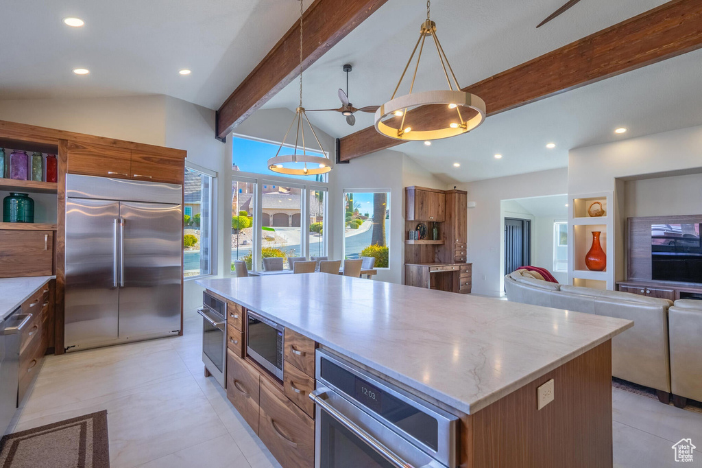 Kitchen featuring brown cabinetry, open shelves, lofted ceiling with beams, built in appliances, and a center island