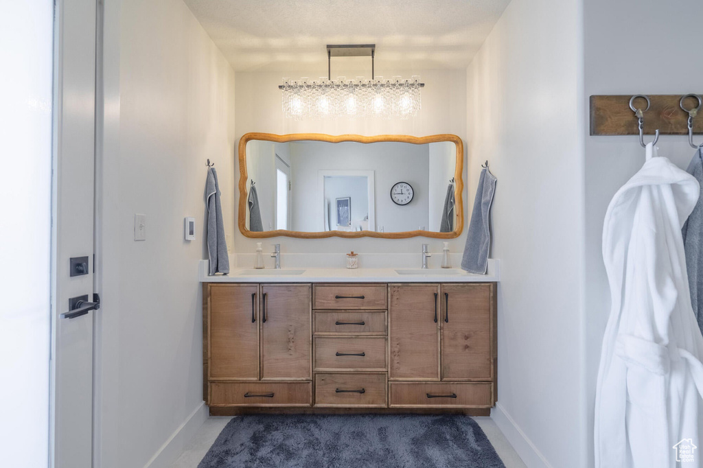 Full bathroom with a sink, baseboards, and double vanity