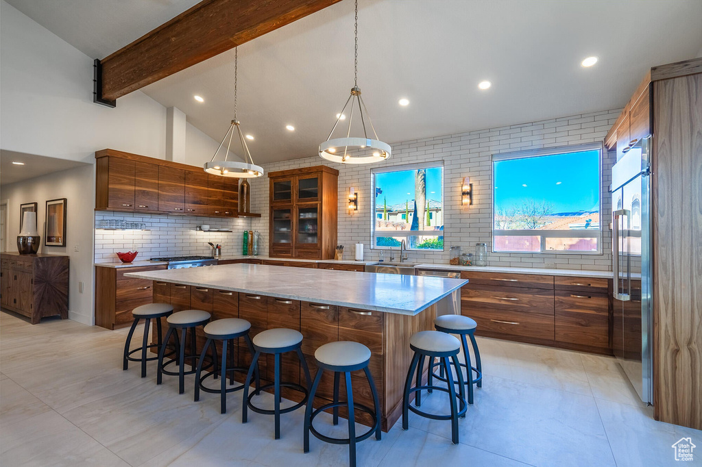 Kitchen with a sink, brown cabinets, a large island, and a breakfast bar