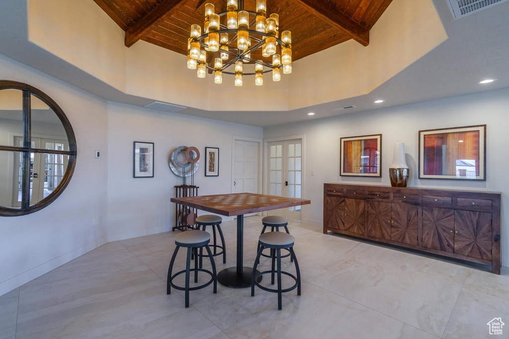 Dining room with beam ceiling, visible vents, wooden ceiling, and french doors