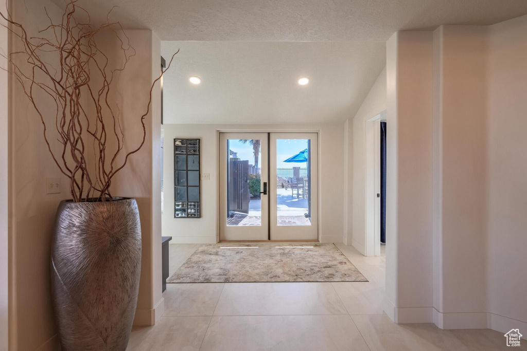 Entrance foyer with recessed lighting, a textured ceiling, baseboards, and vaulted ceiling
