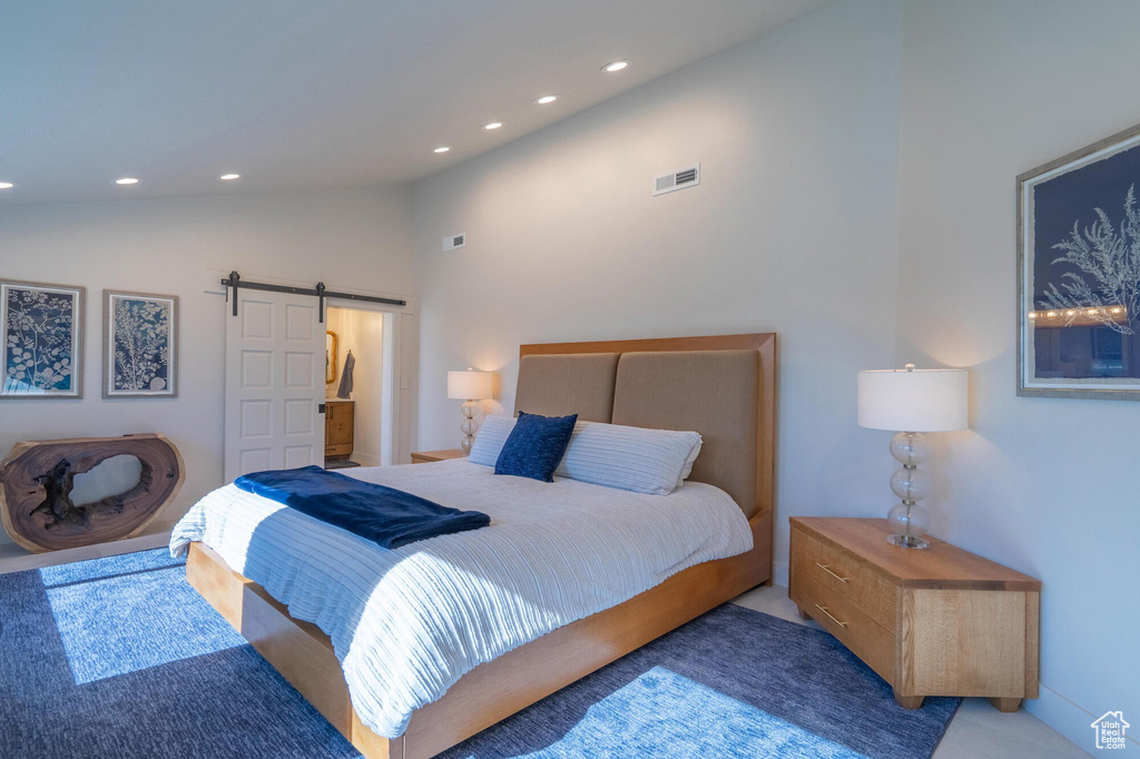 Bedroom featuring a barn door, recessed lighting, visible vents, and lofted ceiling
