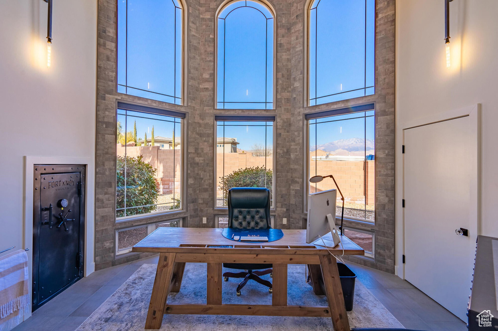 Office featuring a high ceiling and a healthy amount of sunlight