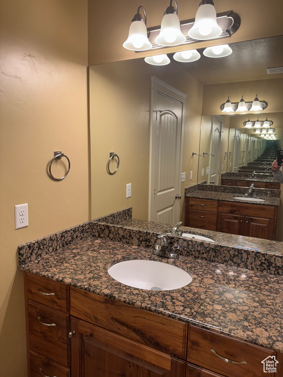 Bathroom featuring vanity, visible vents, and a chandelier
