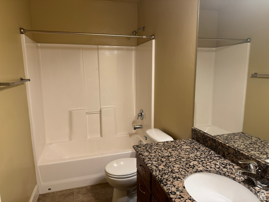 Bathroom with tile patterned flooring, toilet, shower / bathtub combination, and vanity