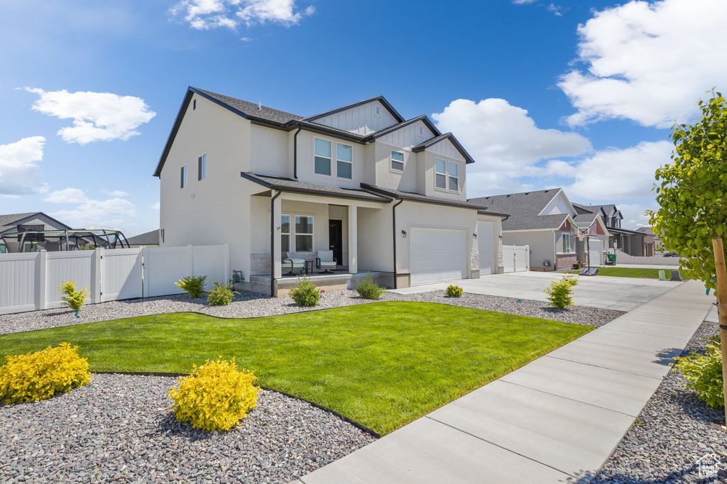 View of front of house featuring an attached garage, concrete driveway, stucco siding, a gate, and a residential view