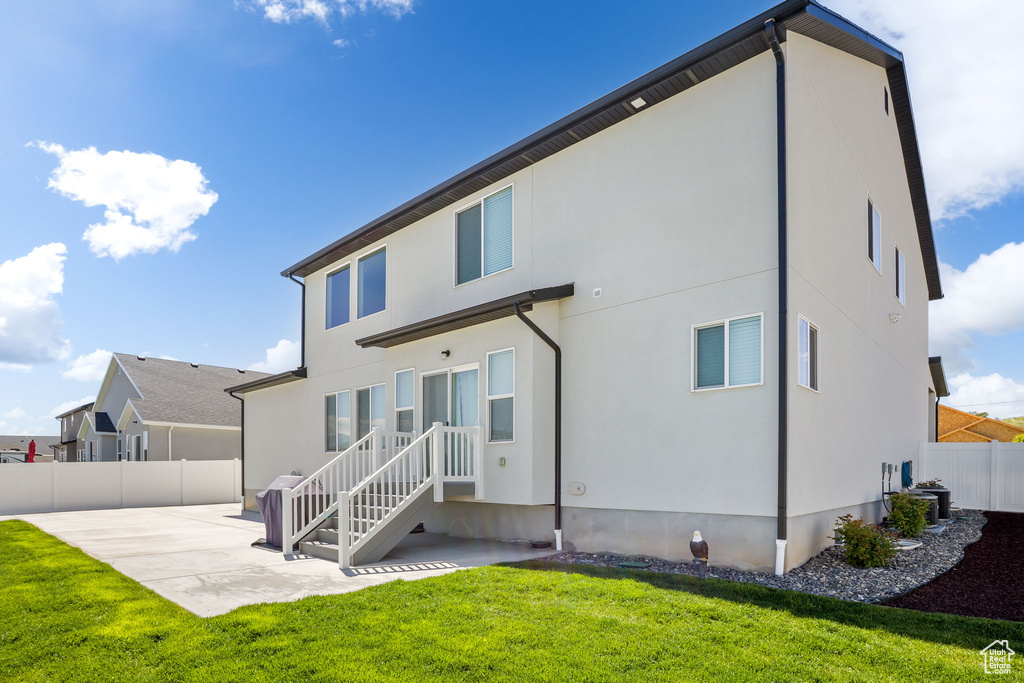 Rear view of house with a patio area and stucco siding