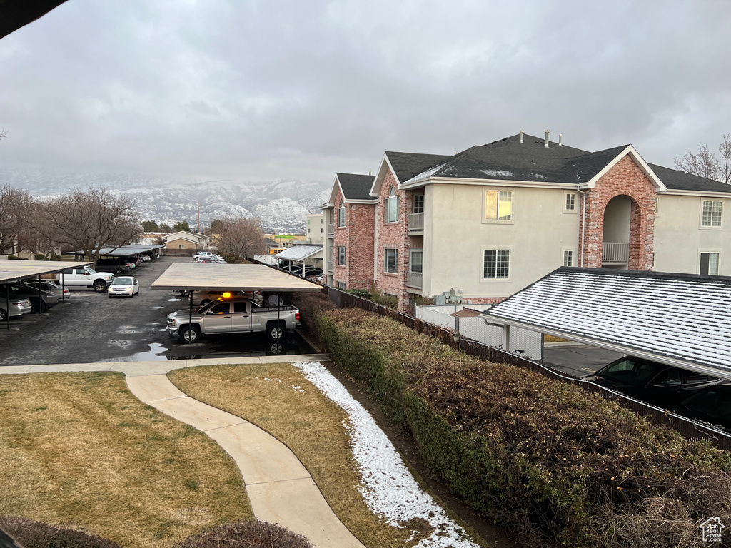 Surrounding community with a carport, a lawn, and a mountain view