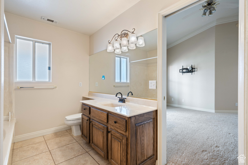Bathroom featuring vanity, toilet, baseboards, and visible vents
