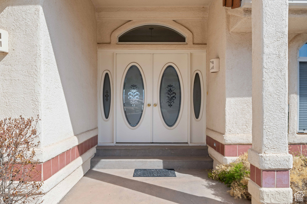 Doorway to property featuring stucco siding