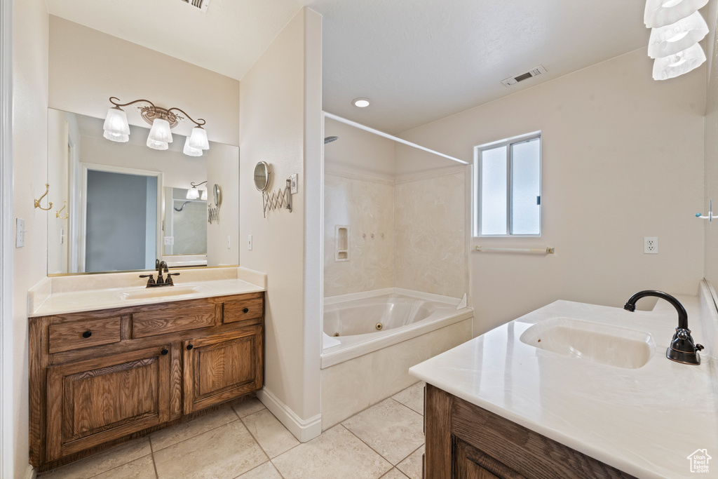 Full bath featuring tile patterned floors, two vanities, visible vents, and a sink