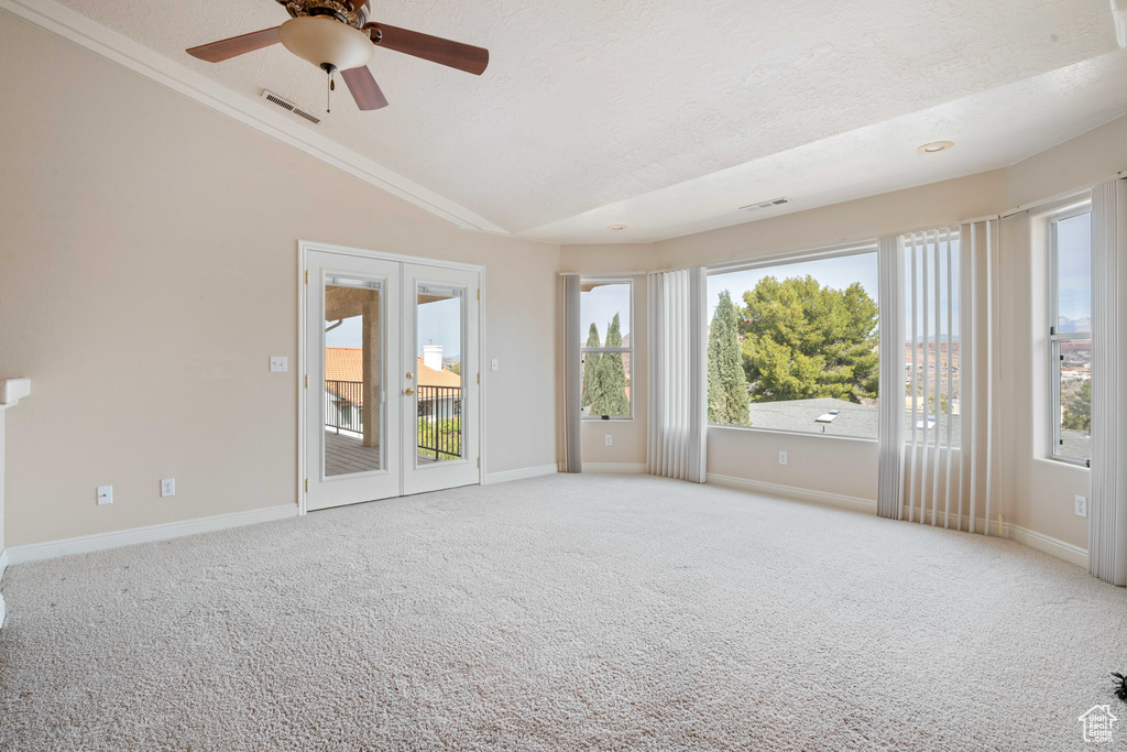Unfurnished room with visible vents, a textured ceiling, carpet floors, and vaulted ceiling
