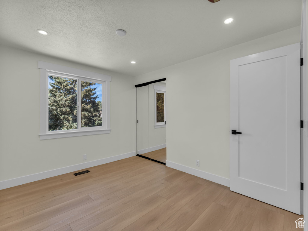 Unfurnished bedroom featuring light wood finished floors, recessed lighting, and baseboards