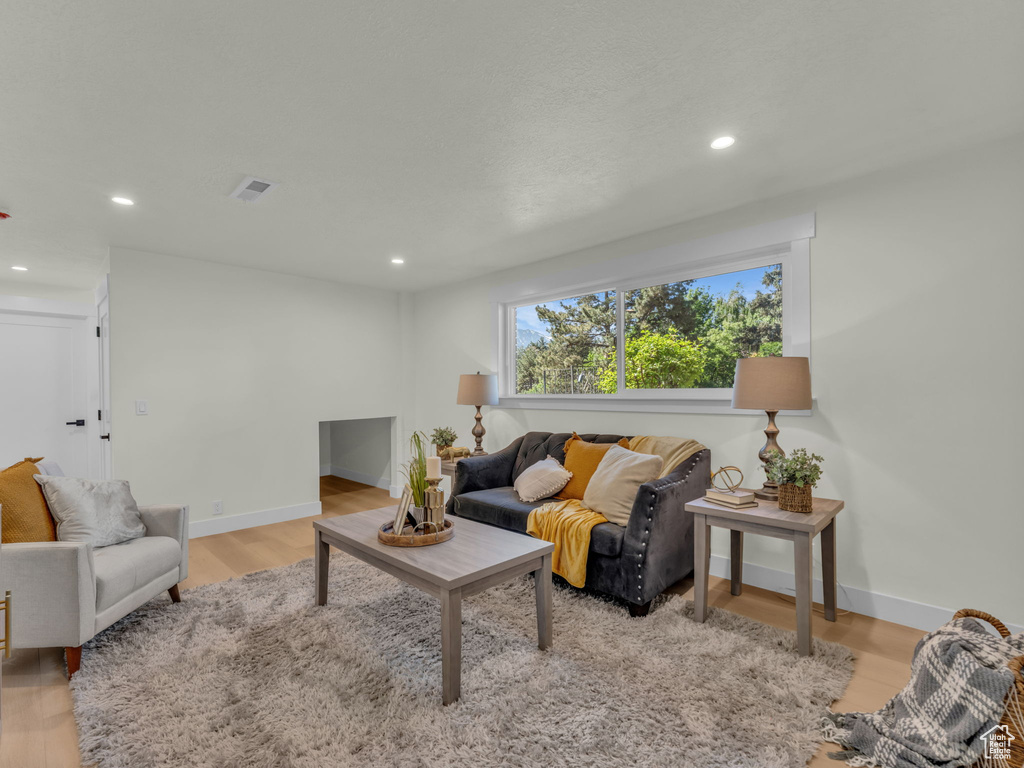 Living room with wood finished floors, recessed lighting, and baseboards