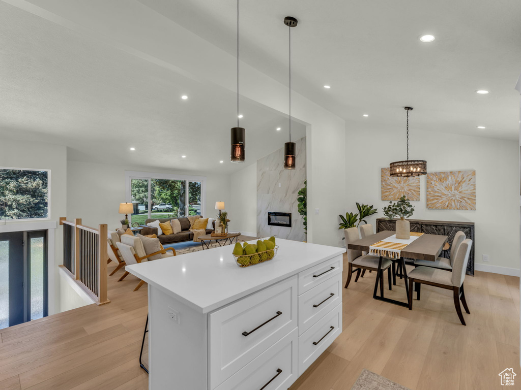 Kitchen featuring white cabinets, light wood-type flooring, a center island, light countertops, and recessed lighting