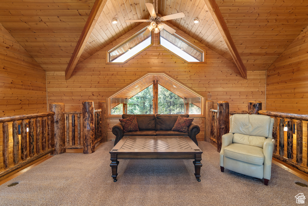 Living area with lofted ceiling with beams, carpet, and wood ceiling
