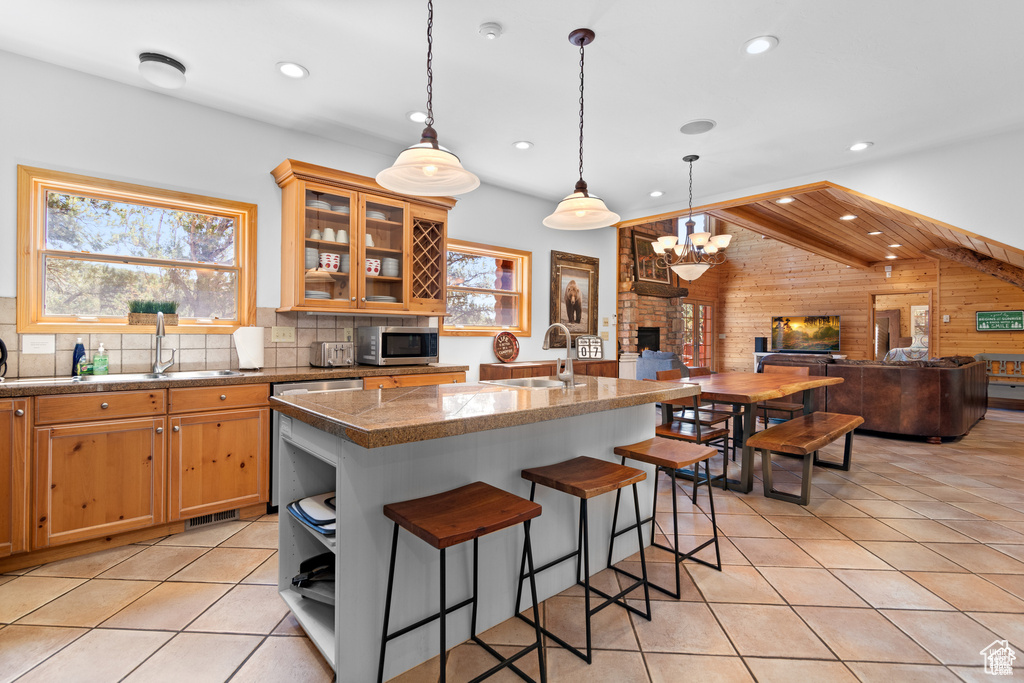 Kitchen with light tile patterned floors, appliances with stainless steel finishes, a wealth of natural light, and a sink