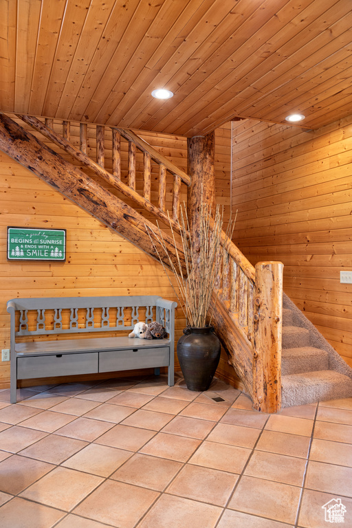 Stairway featuring tile patterned flooring, wooden walls, recessed lighting, and wood ceiling