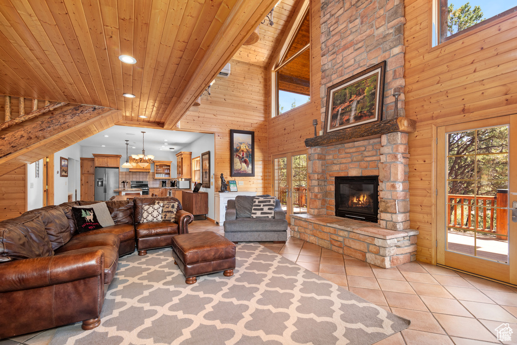 Living area with wooden walls, light tile patterned flooring, a fireplace, recessed lighting, and wooden ceiling