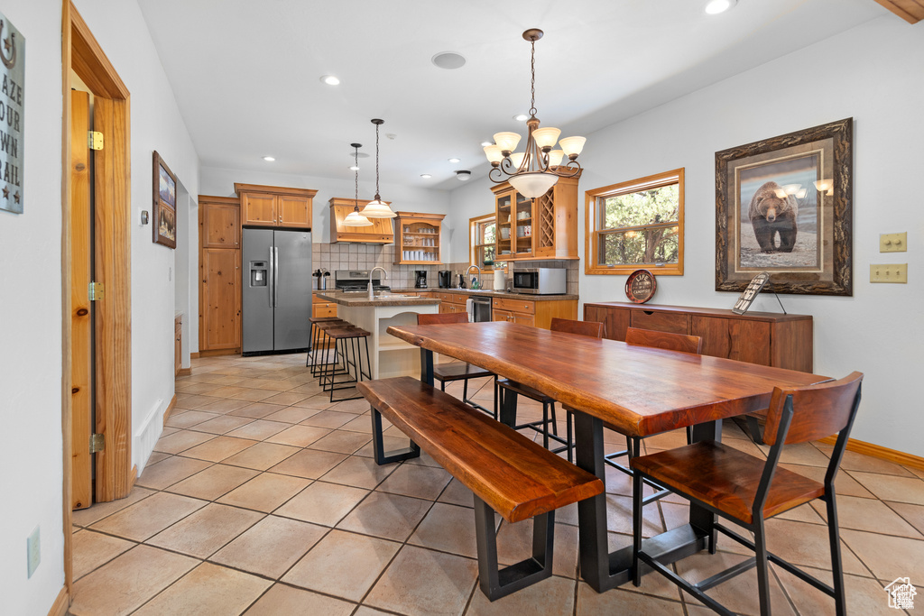 Dining space featuring a chandelier, light tile patterned floors, recessed lighting, and baseboards