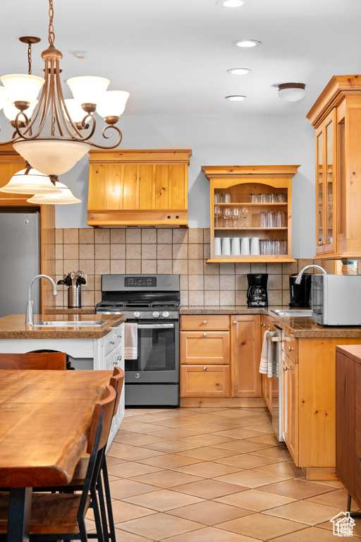 Kitchen with open shelves, decorative backsplash, hanging light fixtures, glass insert cabinets, and appliances with stainless steel finishes