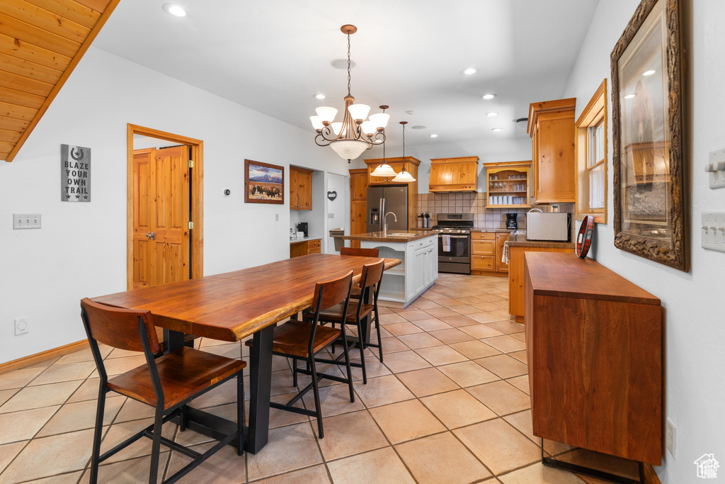 Dining room featuring a notable chandelier, light tile patterned flooring, recessed lighting, and baseboards