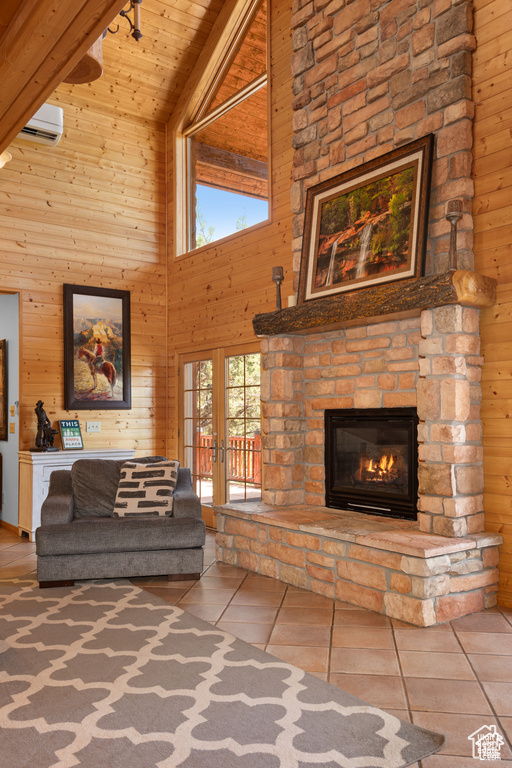 Living room featuring tile patterned flooring, wooden walls, french doors, a fireplace, and wooden ceiling