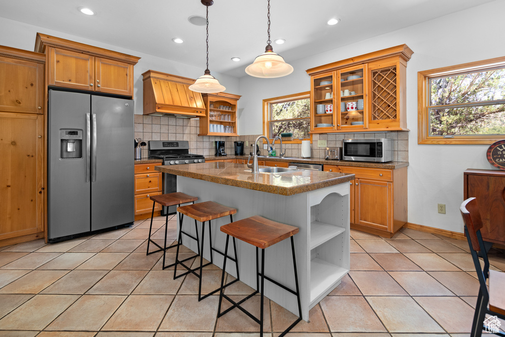 Kitchen with custom range hood, open shelves, a sink, appliances with stainless steel finishes, and light tile patterned floors