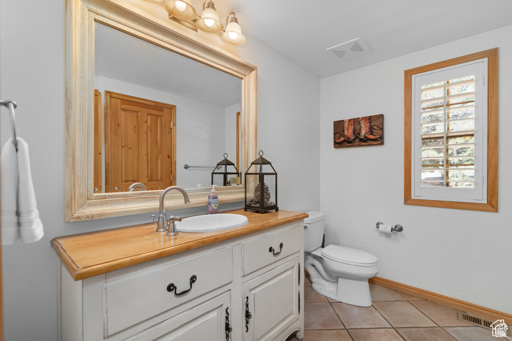 Bathroom with vanity, tile patterned floors, toilet, and visible vents